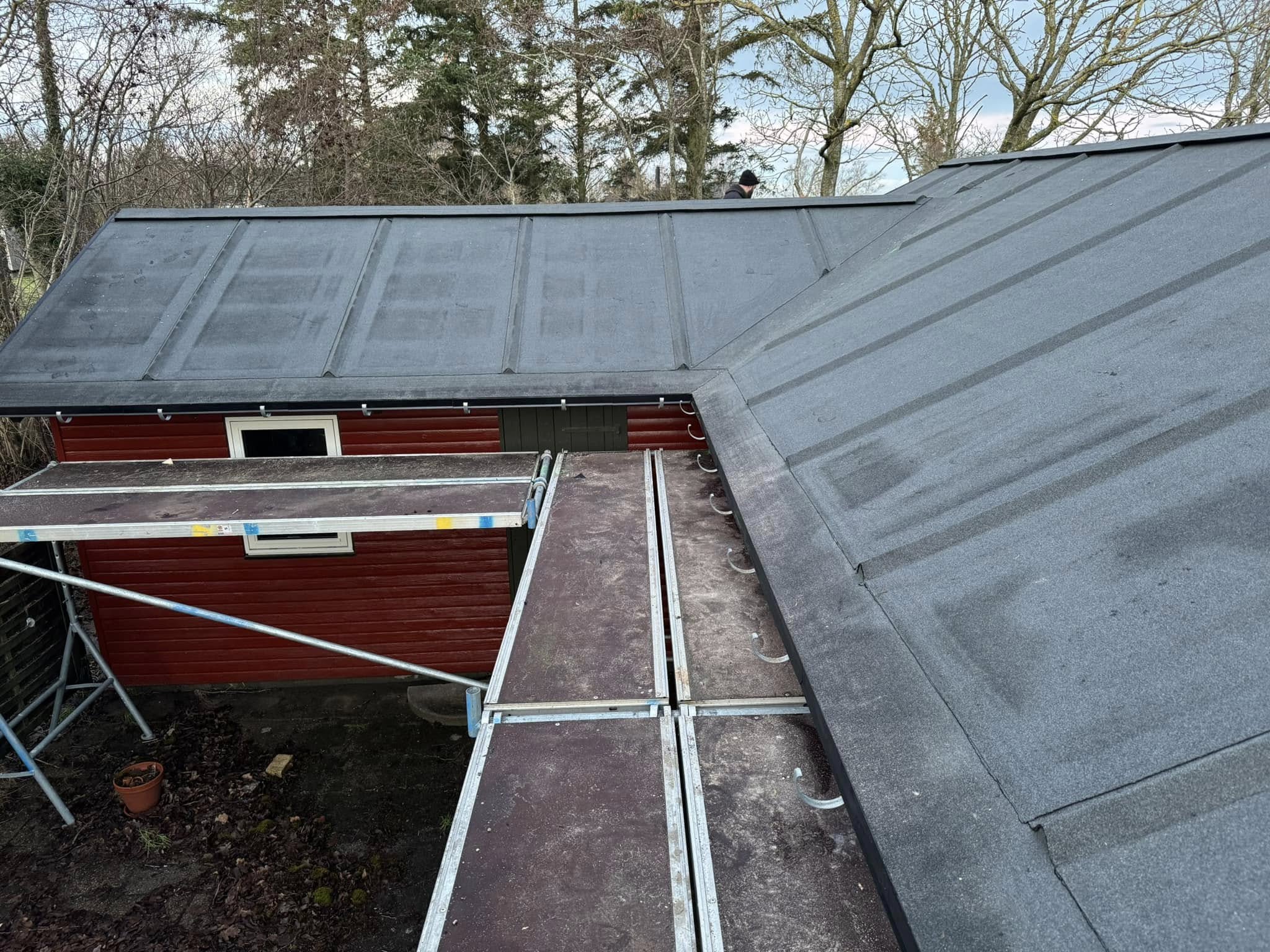 Tagpap under montering på rød bygning